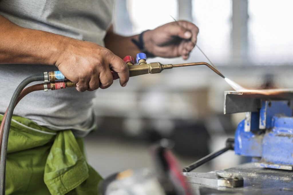 Cropped view of man welding in bodywork repair shop